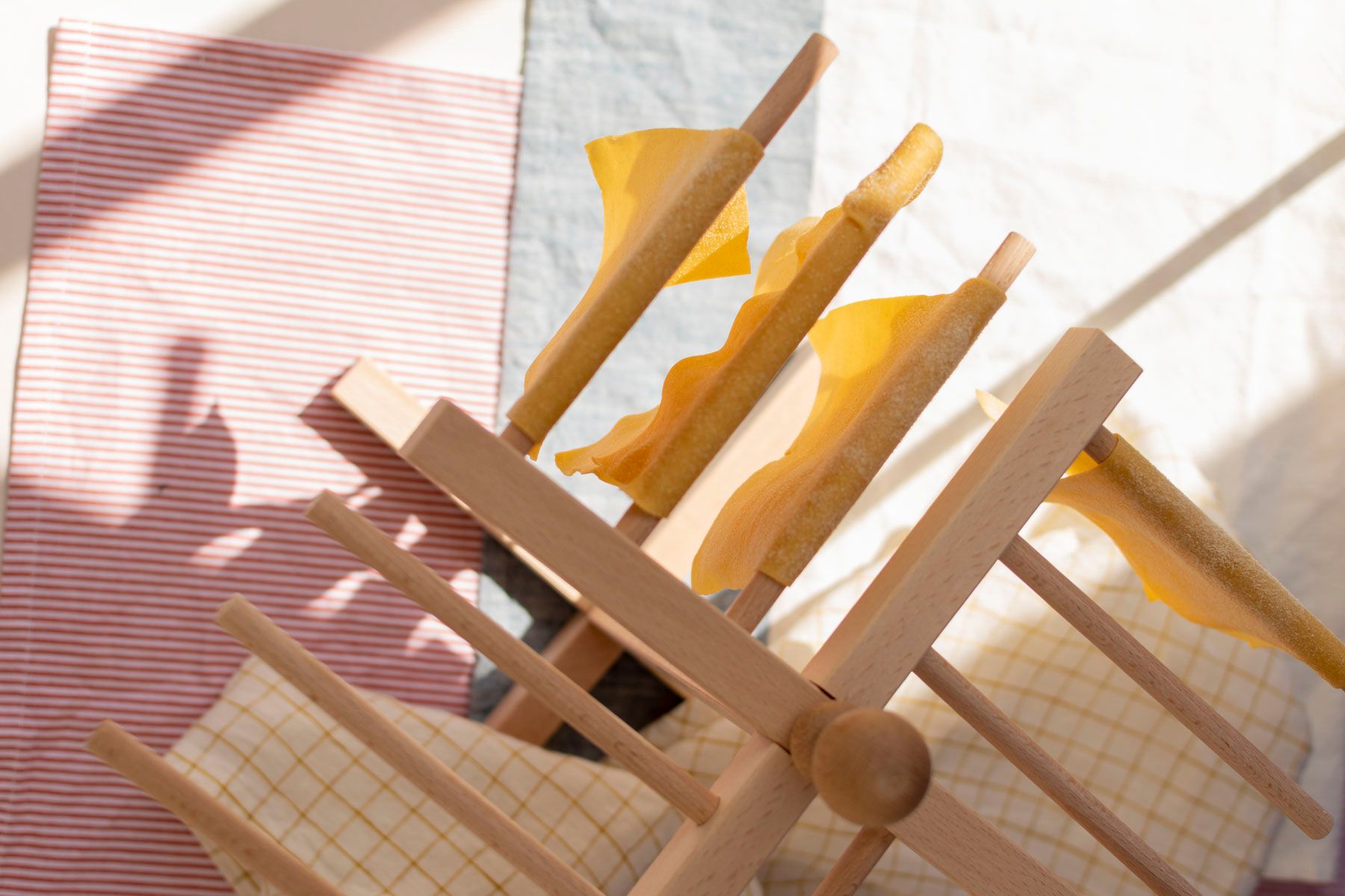 séchoir à pâtes sur lequel pendent des lasagnes réalisés avec le cours de cuisine italienne d'Artesane